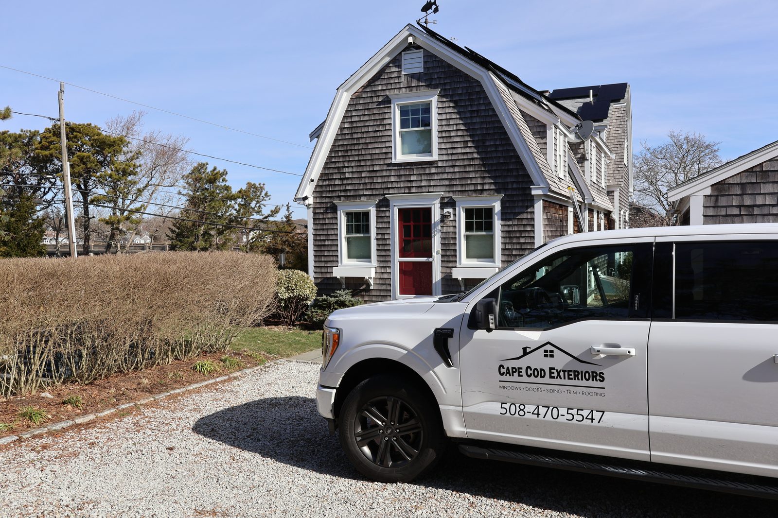 Cape Cod Exteriors truck at shingle home with red door