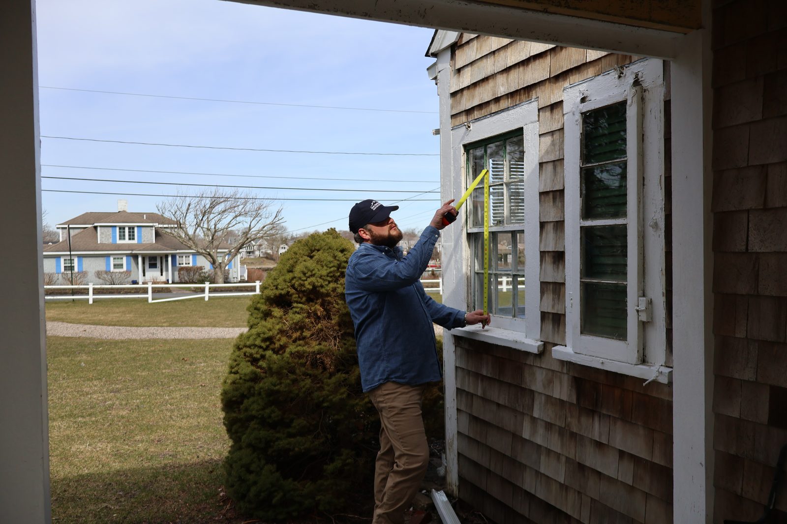 Measuring window for replacement on Cape Cod home