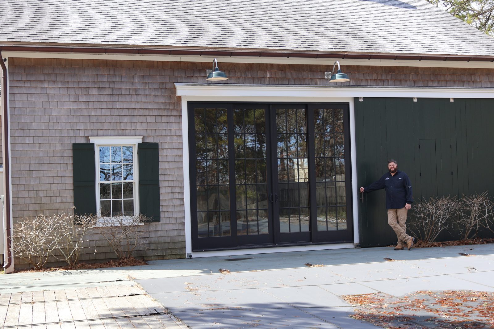Black patio door system installed on Cape Cod shingle home